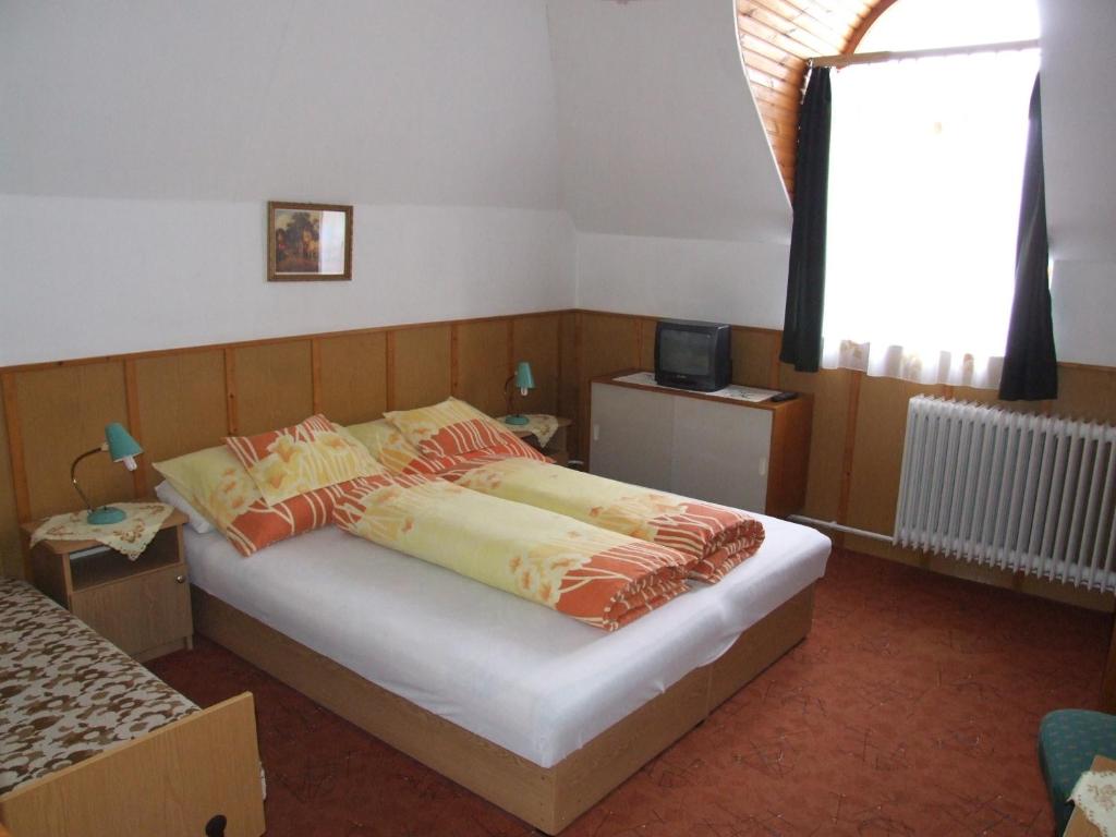 een slaapkamer met een bed en een raam bij Révész Vendégház in Harkány
