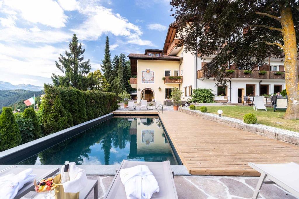 uma villa com uma piscina e uma casa em Solaia Hotel & Guesthouse em Castelrotto
