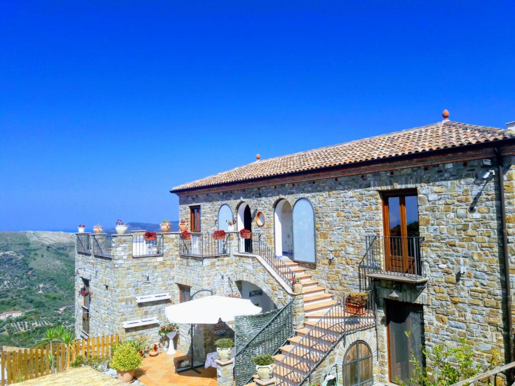 un edificio in pietra con scale e balcone di Il Canto Dei Venti a Montecorice