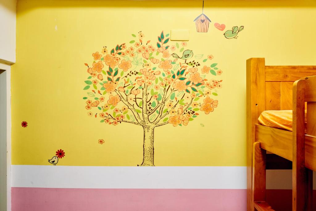 a tree mural on the wall of a bedroom at Corner Inn九份住宿I 小角落民宿I 機車租借I日夜間導覽 in Jiufen