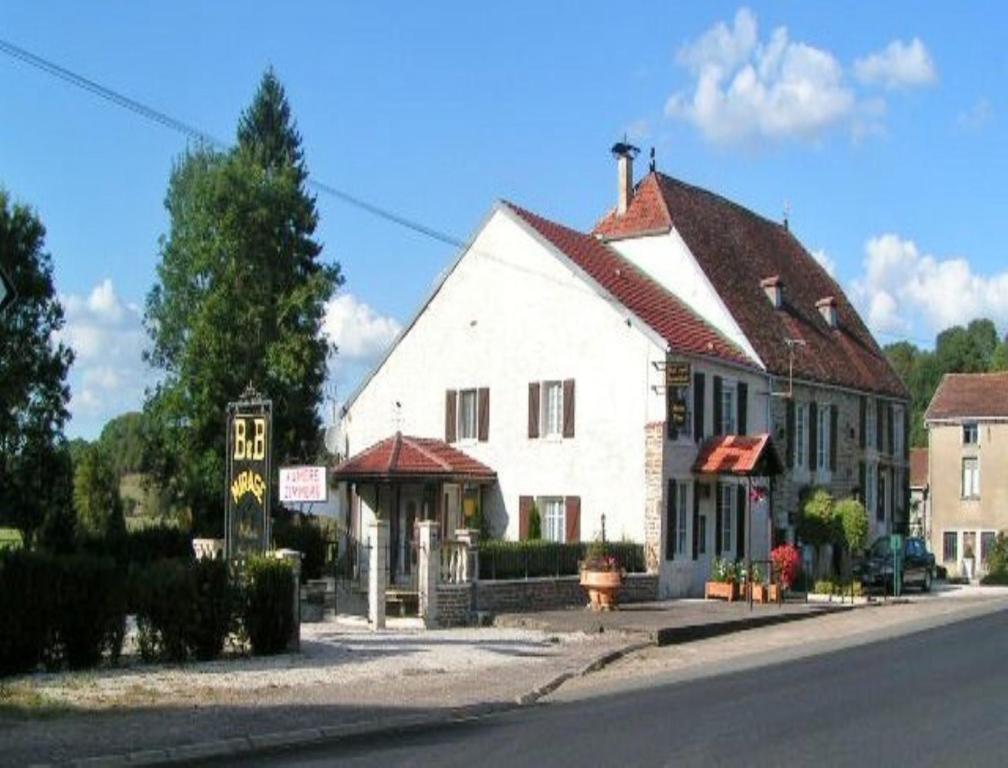 a large white building on the side of a street at B&B Mirage in Frécourt