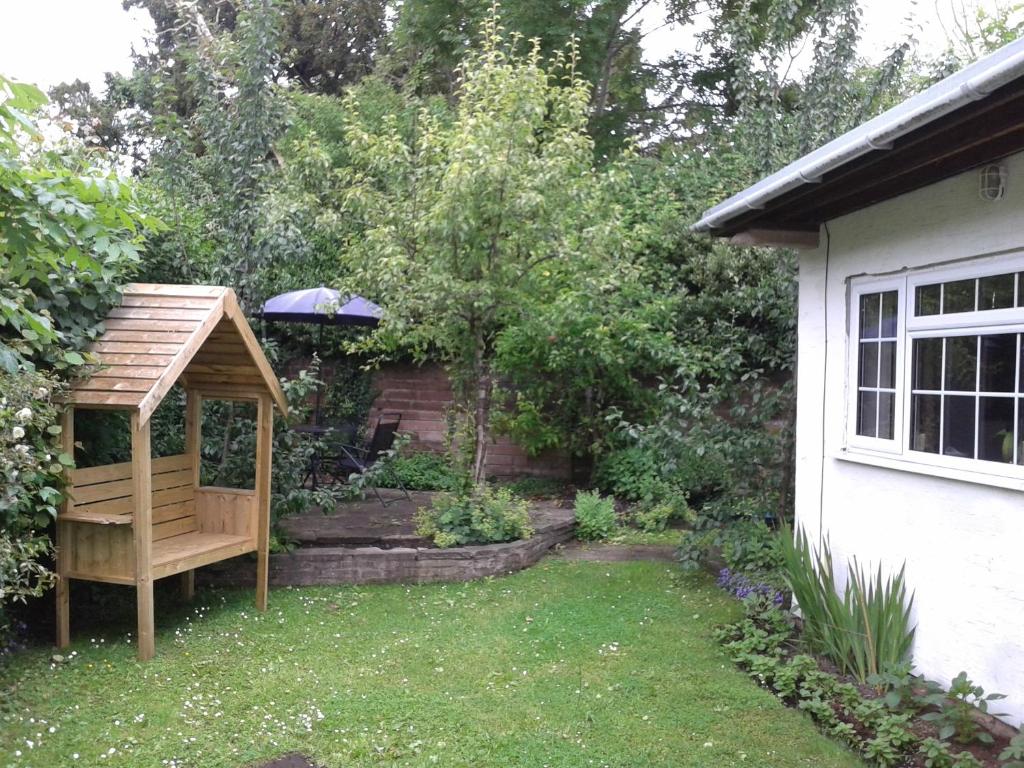 a garden with a gazebo next to a house at Railway Cottage in Cardiff