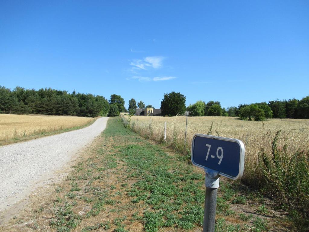 a sign on the side of a road next to a field at Okker Gokker Gården in Allingåbro