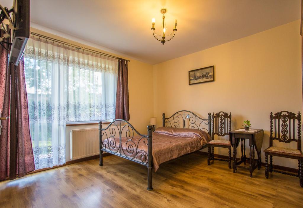 1 dormitorio con cama y ventana en Willa Natia, en Kluszkowce