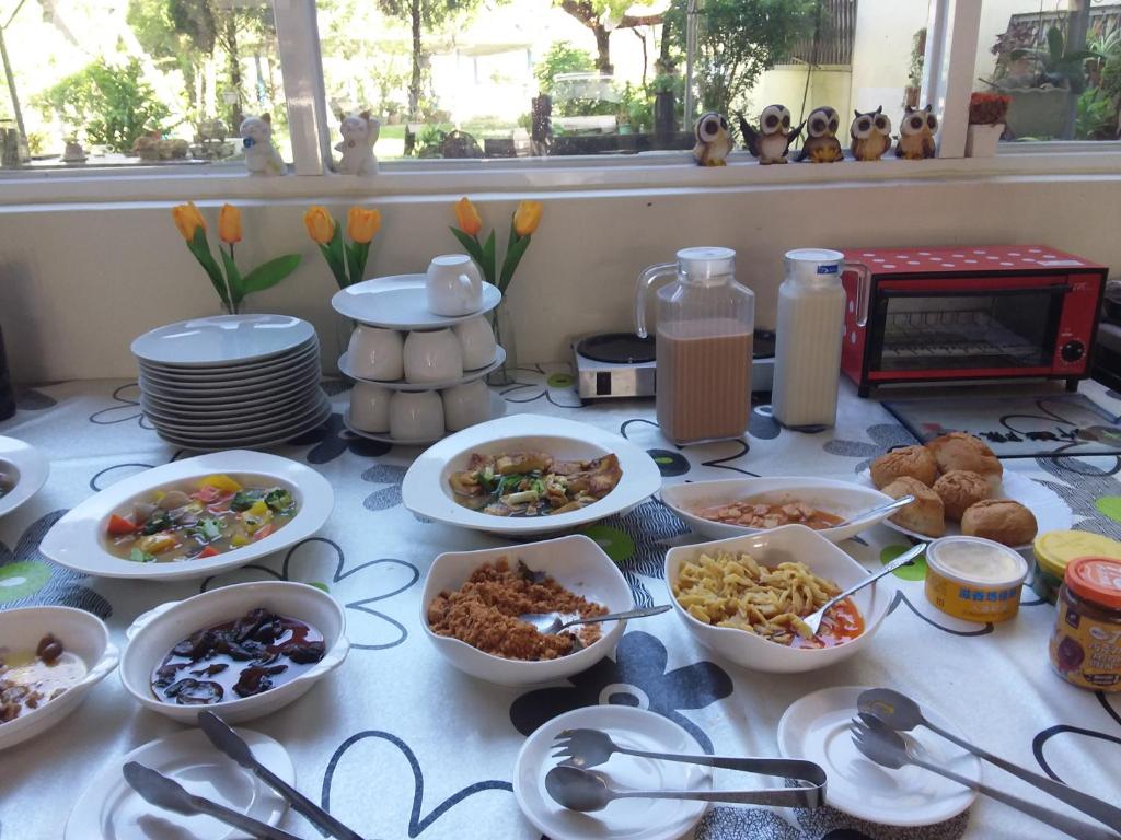 uma mesa coberta com tigelas e pratos de comida em Niuniu & Meng Ka Homestay em Liugui