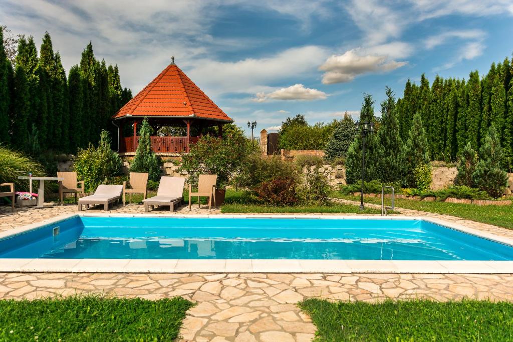 una piscina en un patio con cenador en Bella Vendégház Palkonya, en Palkonya