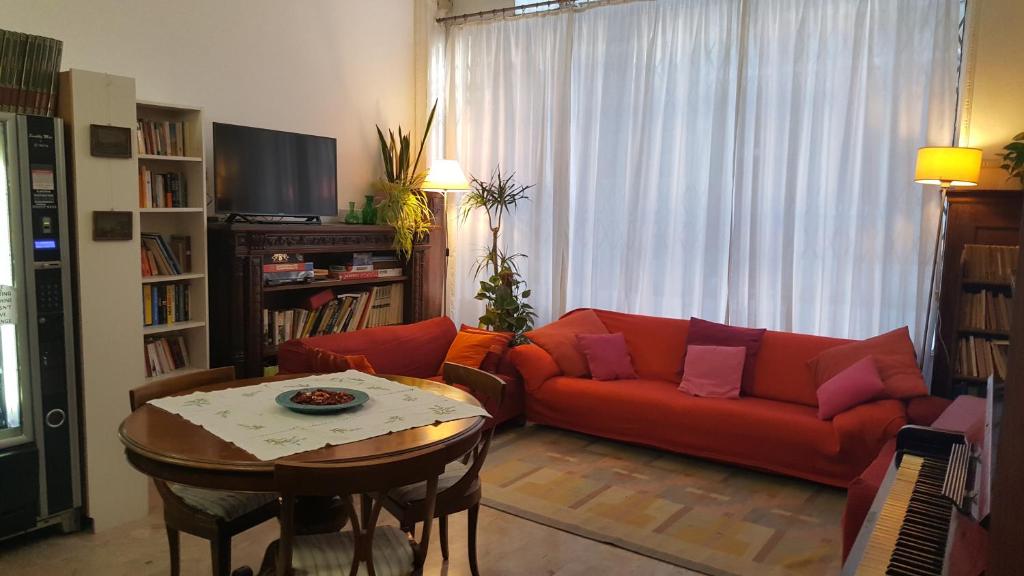 a living room with a red couch and a table at Ostello Domus Civica in Venice