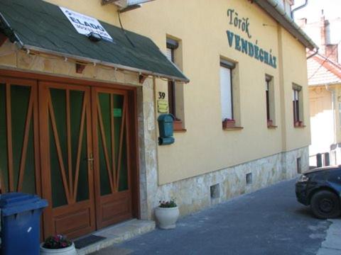 un edificio con una puerta y un coche aparcado fuera en TÖRÖK VENDÉGHÁZ, en Sopron