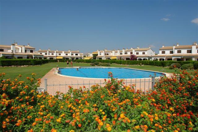 una gran piscina en un patio con flores en La Platera Villas, en L'Estartit