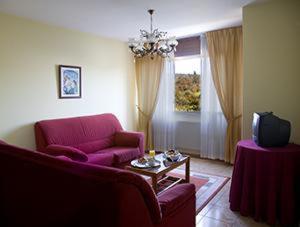 sala de estar con sofá rojo y TV en Hotel Millan, en Negreira
