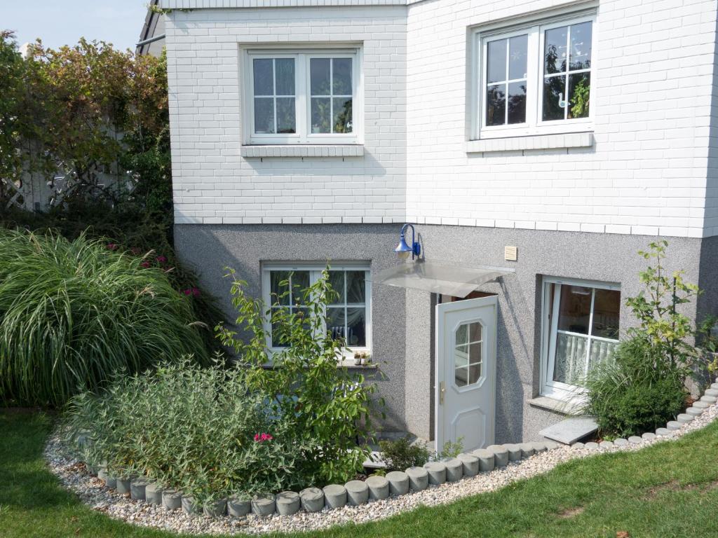 a white house with a blue door and some plants at Ferienwohnung Holunderweg in Bad Doberan