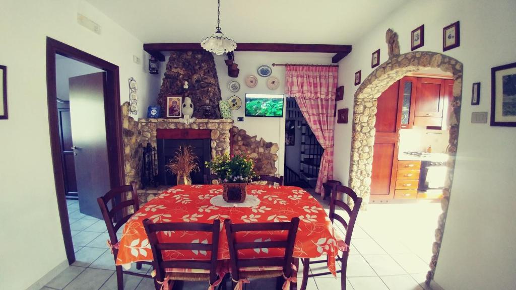 comedor con mesa roja y sillas en Villa Frantoio en Mattinata