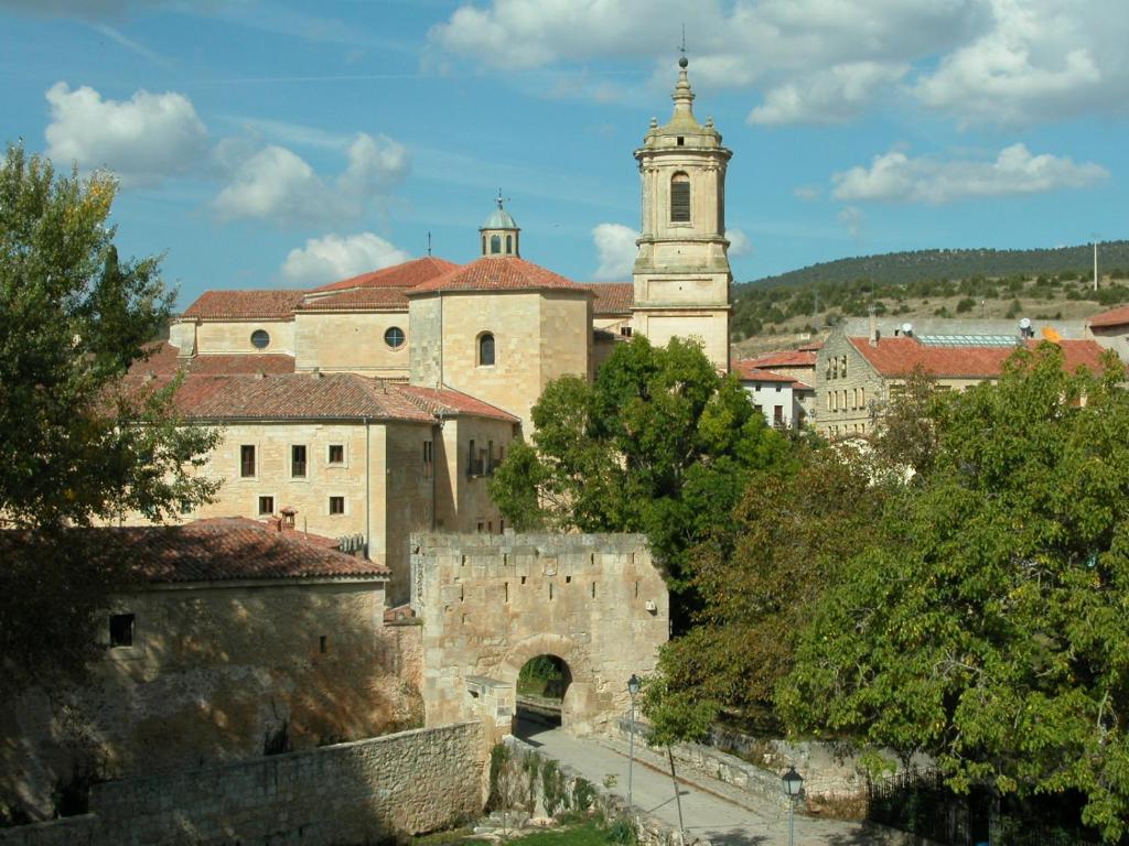 um edifício antigo com uma torre de relógio numa cidade em Casa Rural Las Condesas em Santo Domingo de Silos