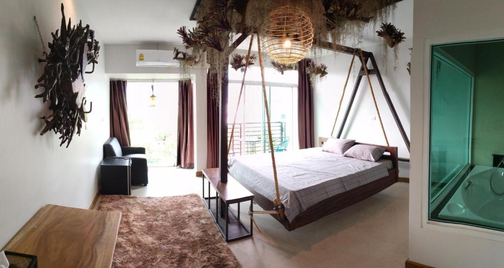 a bedroom with a canopy bed and a large window at Arbor's house in Chiang Mai