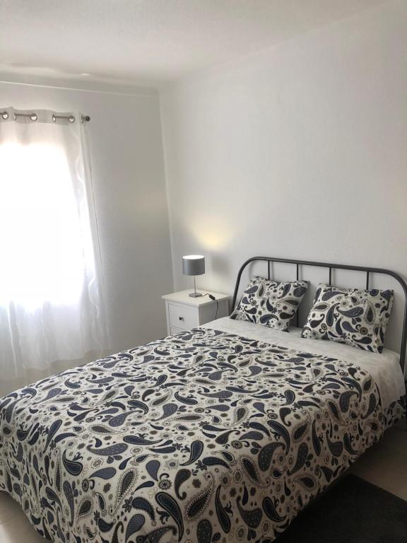 ラゴスにあるOlinda’s 2 Bedroom Apartmentのベッドルーム1室(ベッド1台、白黒の掛け布団付)