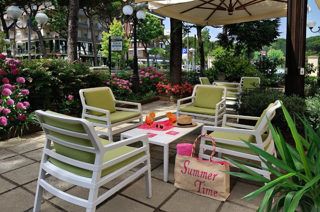 un grupo de sillas de jardín y una mesa con una comida. en Hotel Suisse, en Milano Marittima