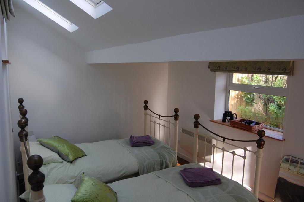 two twin beds in a room with a window at Little Woodacott in Barnstaple