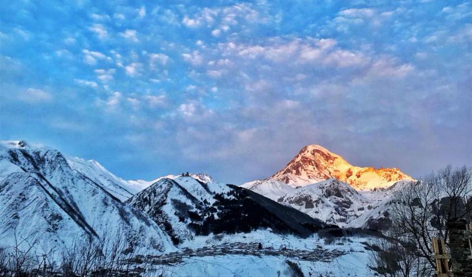 a mountain covered in snow under a cloudy sky at Riverside Kazbegi in Stepantsminda