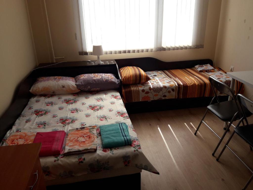 1 Schlafzimmer mit 2 Betten, einem Tisch und Stühlen in der Unterkunft Guest House Mania in Sofia