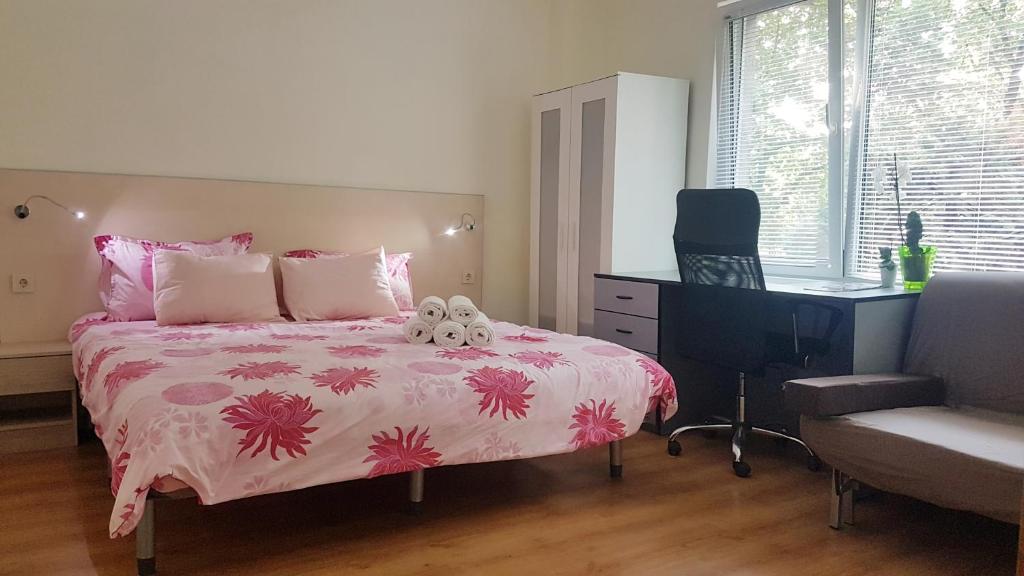 een slaapkamer met een bed, een bureau en een stoel bij Malavi top center studio Ruse! Comfort&clean! in Ruse