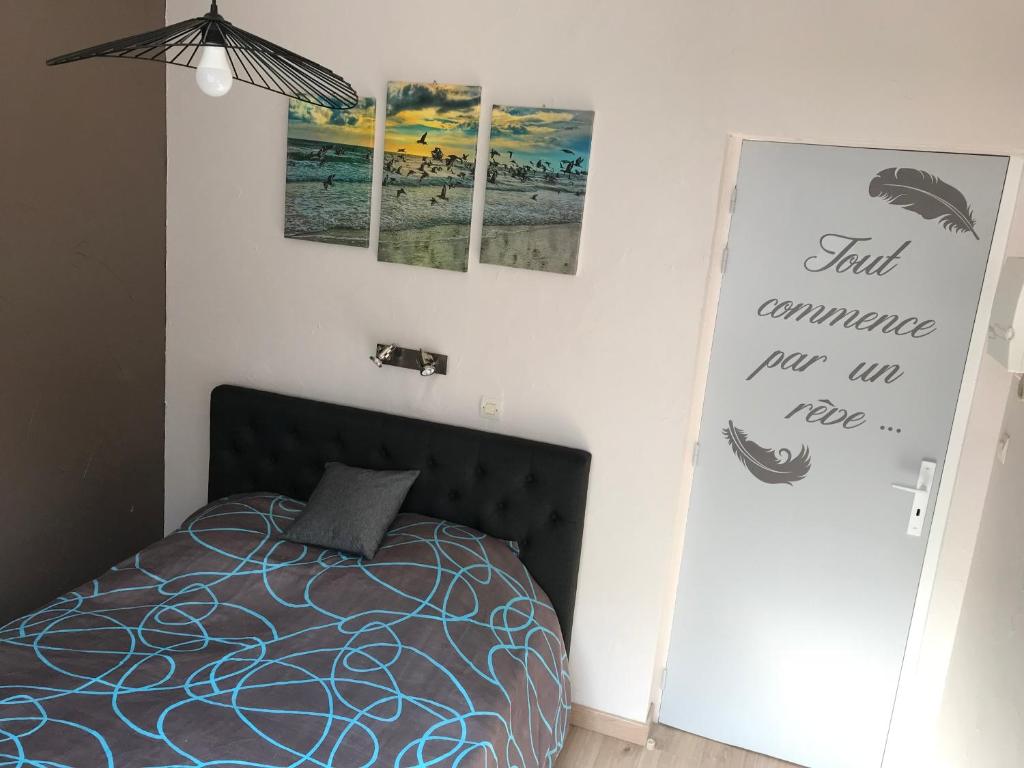 a bedroom with a bed and posters on the wall at Lumineux T2 Vieille ville 3 pers parking gratuit - by La Source d&#39;OrFée in Boulogne-sur-Mer