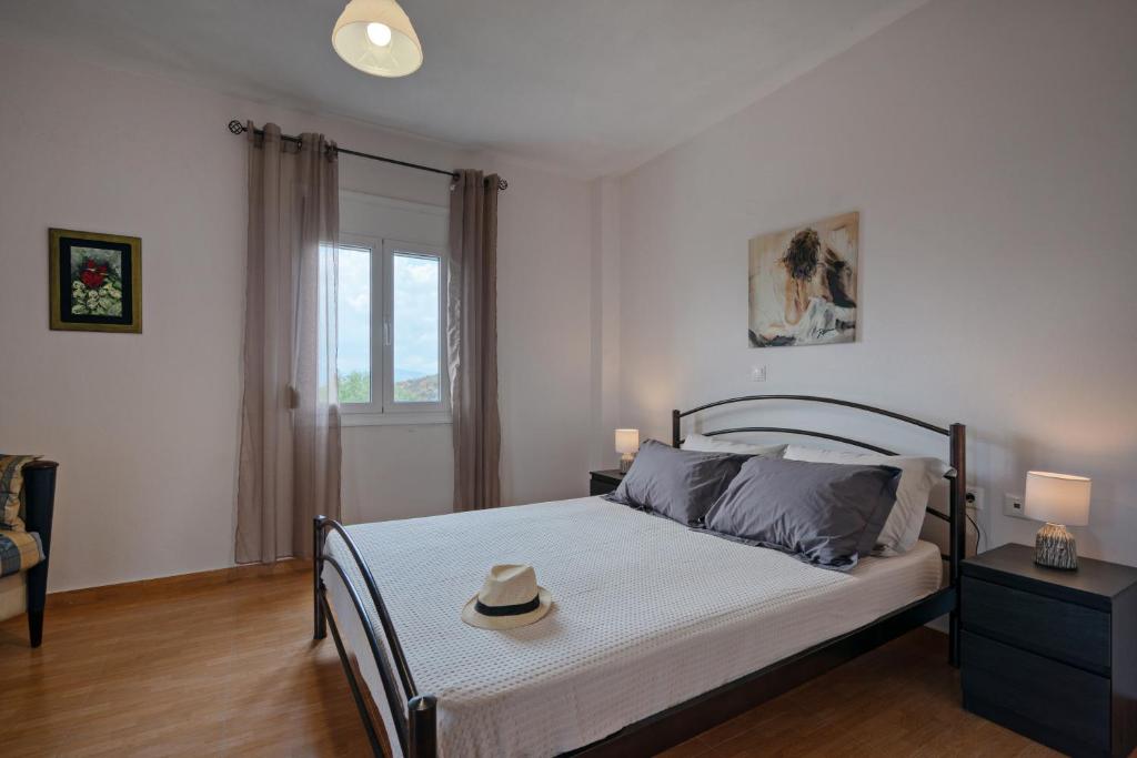 sypialnia z łóżkiem z kapeluszem w obiekcie Aliki Serenity Cottage w mieście Mixórrouma