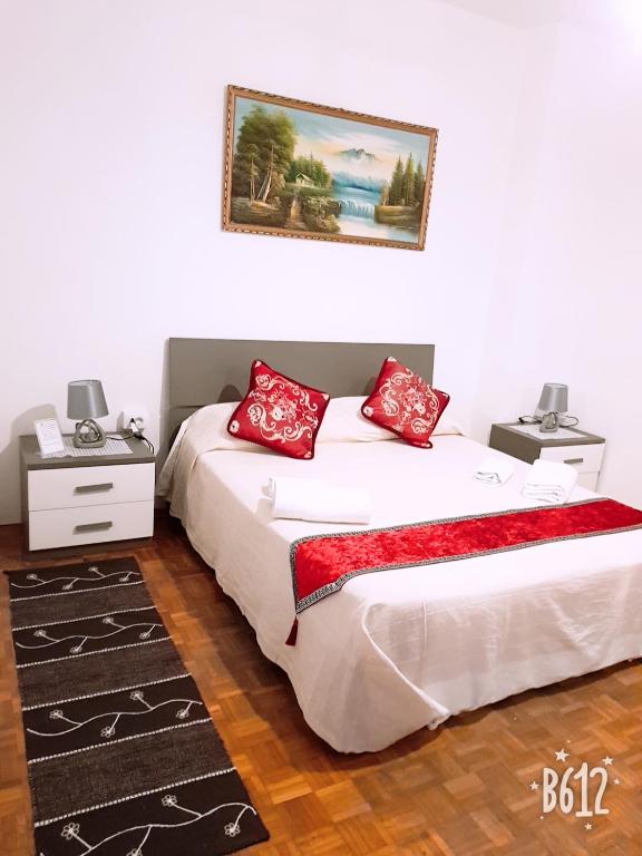 two beds with red pillows in a room at BB Stay Station in Mestre