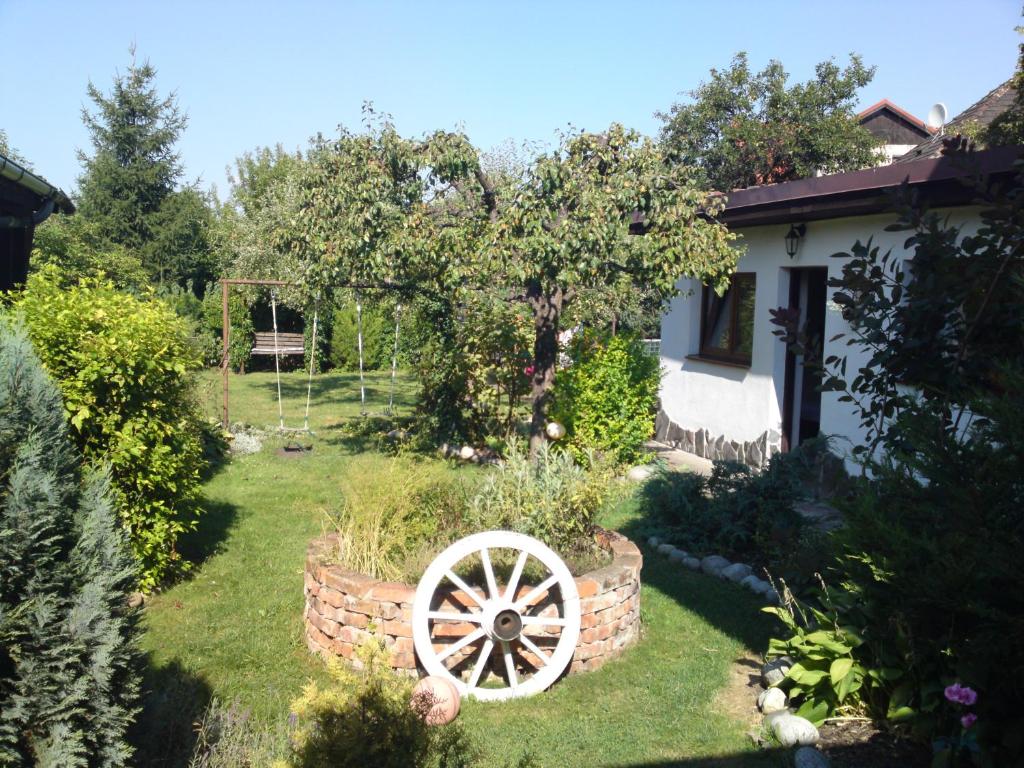 a garden with a wagon wheel in the yard at Mikulas Guest House in Liptovský Mikuláš