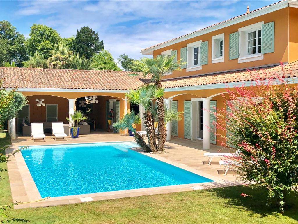 a villa with a swimming pool in front of a house at Villa luxueuse avec piscine sur les hauts de Biarritz in Biarritz
