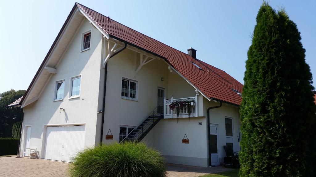 una casa blanca con un garaje y un árbol en Lieblingsplatz, en Altenstadt