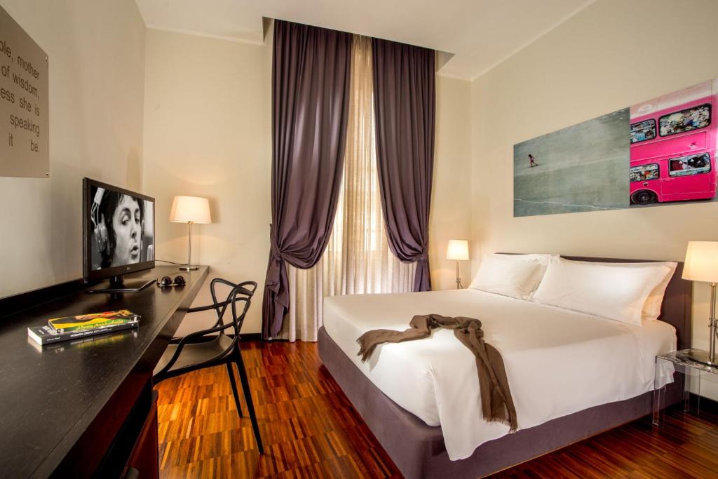 une chambre avec un lit, un bureau et une fenêtre dans l'établissement Suitedreams, à Rome
