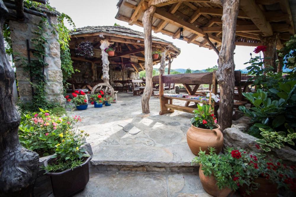 an outdoor patio with potted plants and a wooden pavilion at Stara Hercegovina in Trebinje
