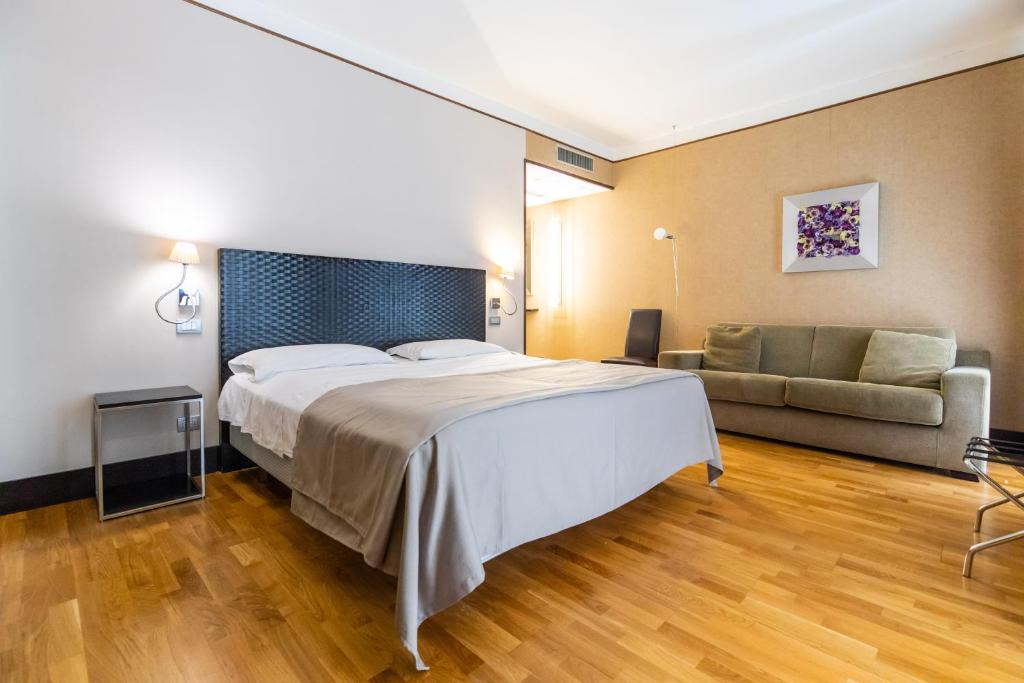 una camera d'albergo con letto e divano di MH Design Hotel a Napoli