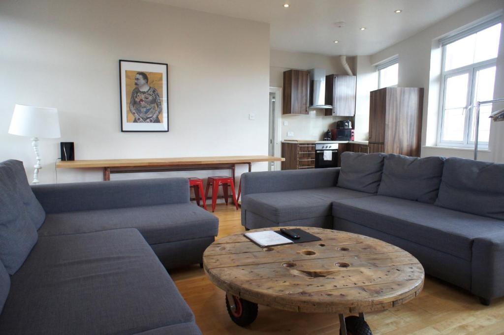 a living room with two blue couches and a coffee table at Heart of Shoreditch in London