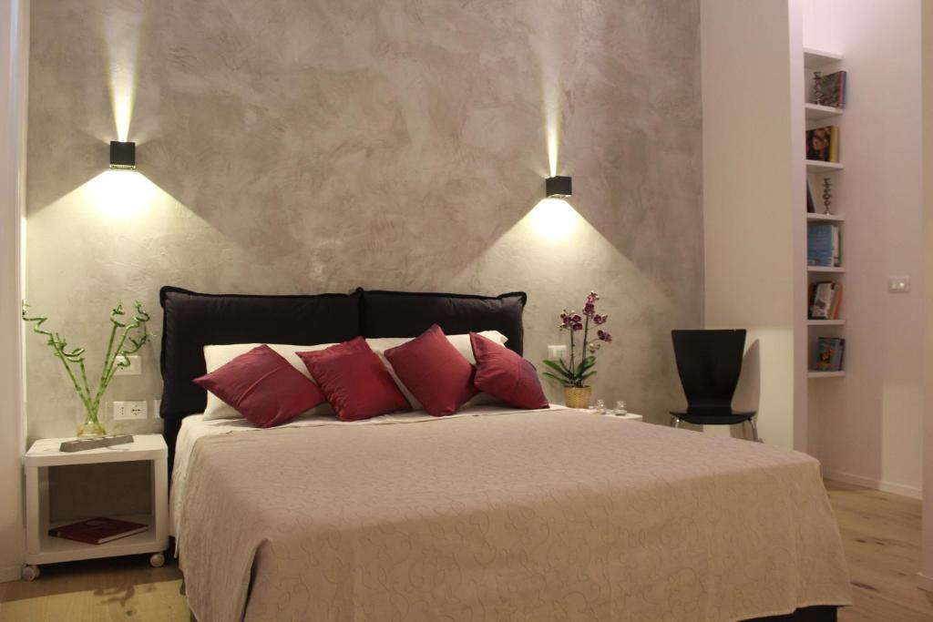 ein Schlafzimmer mit einem großen Bett mit zwei roten Kissen in der Unterkunft Pangea Suite - Vaticano in Rom