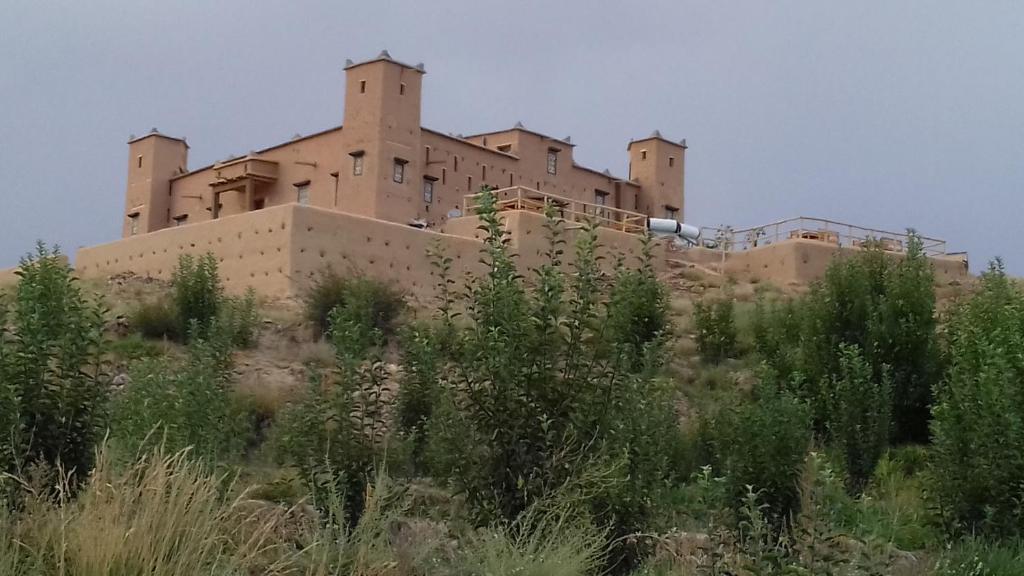 ein großes Gebäude auf einem Hügel mit Pflanzen in der Unterkunft Kasbah Izoran in Midelt