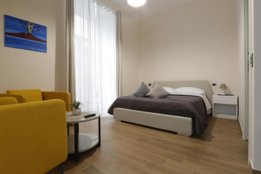 拿坡里的住宿－Musto Suites & Rooms，一间卧室配有一张床、一张沙发和一张桌子