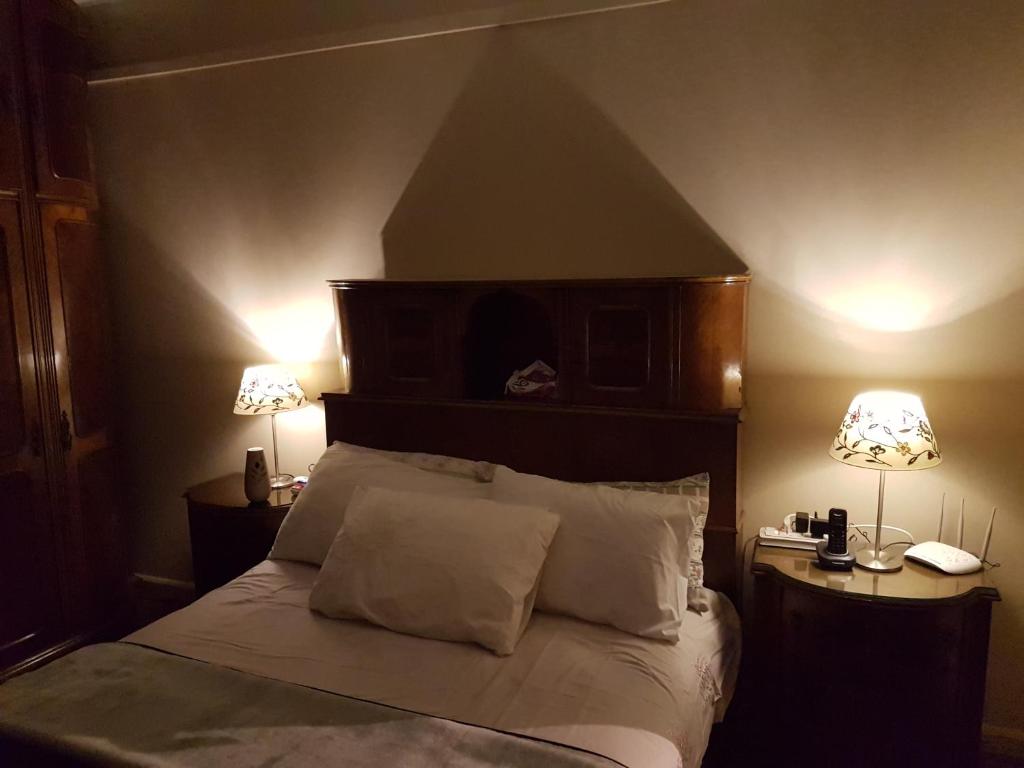 Cozy modern apartment في القاهرة: غرفة نوم مع سرير مع مصباحين على طاولتين