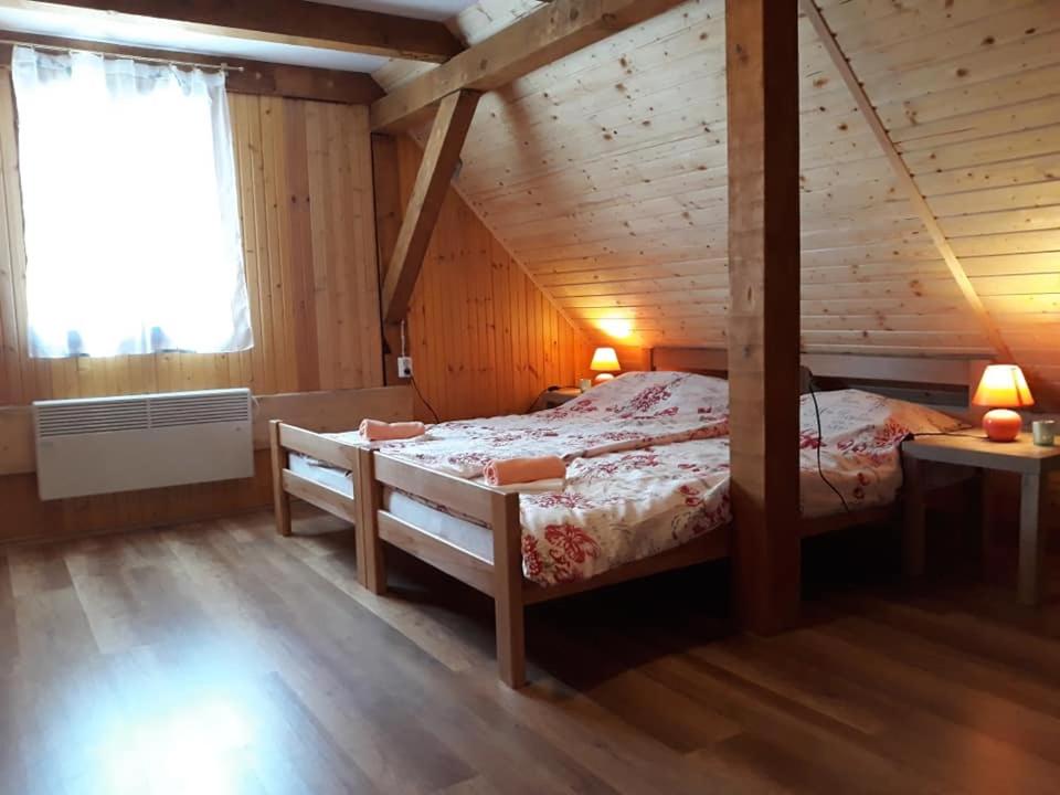 um quarto com uma cama grande num quarto de madeira em Kuća za odmor "Seka"*** em Mrkopalj