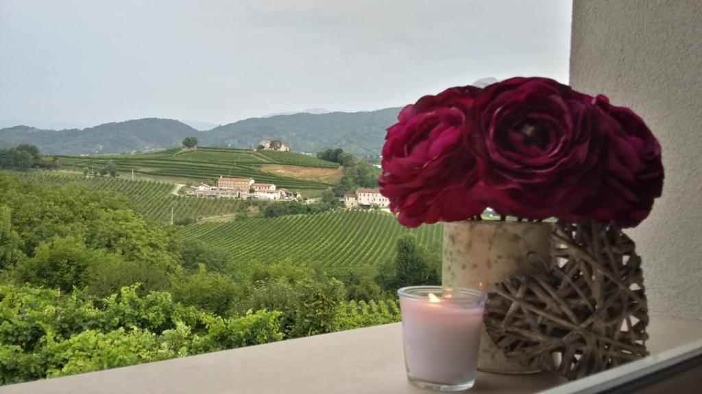 une bougie et un vase avec une fleur et un verre dans l'établissement La Casetta, à Vittorio Veneto