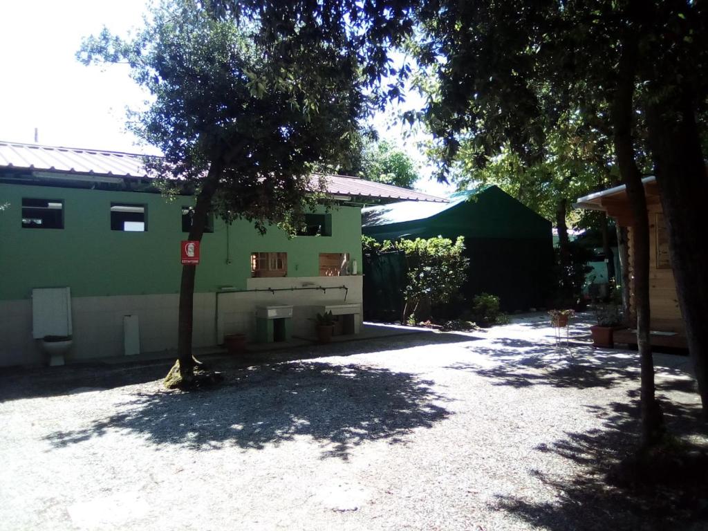 una casa con un árbol en medio de una entrada en Camping Verde en Massa