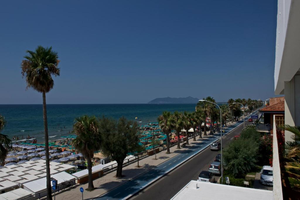 a view of a beach with palm trees and the ocean at Hotel Ristorante Centosedici in Terracina