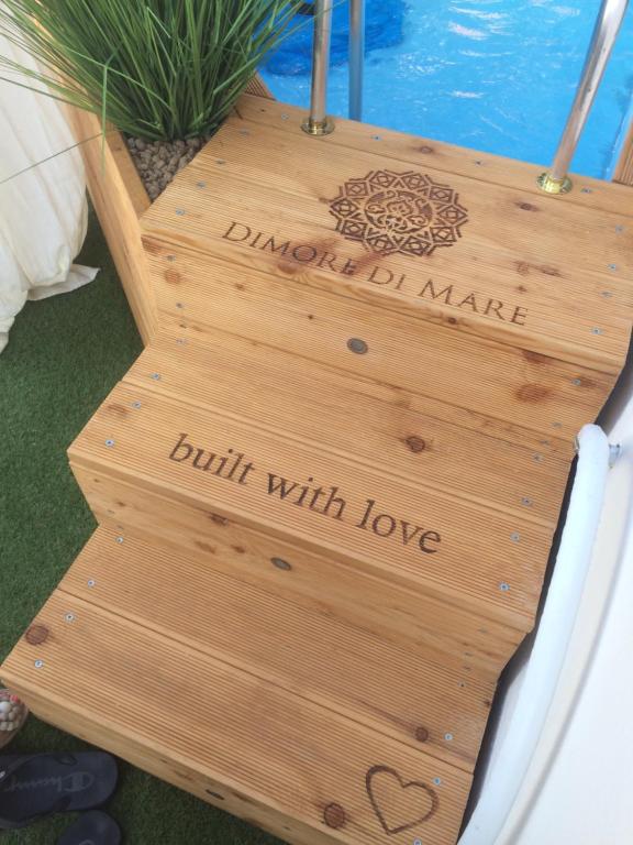 a wooden staircase with a sign that reads built with love at Dimore di Mare in San Pietro Vernotico