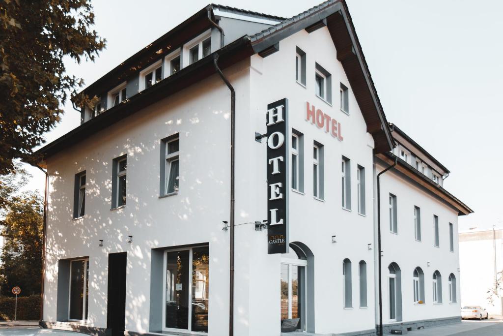 un bâtiment blanc avec un toit noir dans l'établissement Hotel Castle Rastatt, à Rastatt