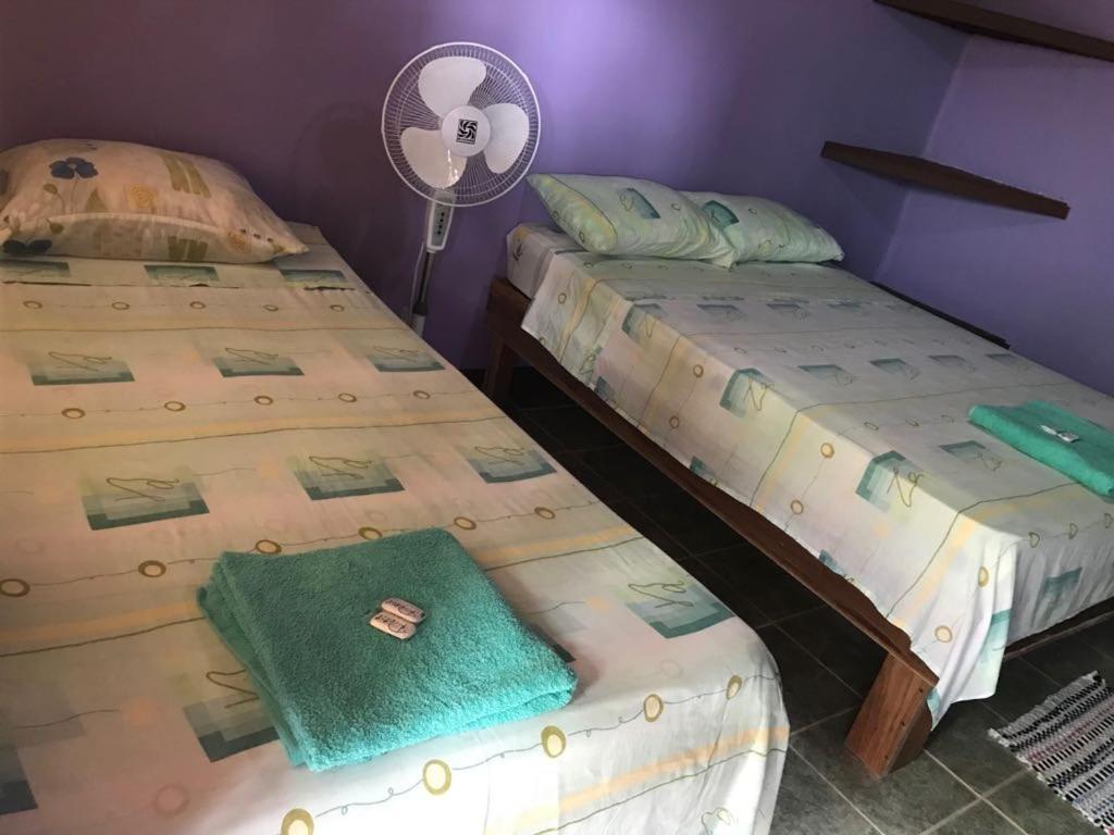 two beds sitting next to each other in a room at Cabinas Surf Side in Cahuita