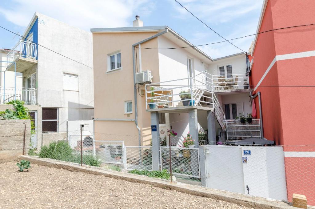uma casa com uma cerca em frente em Apartments Dasa em Primošten