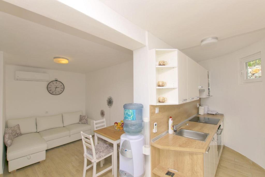 Una cocina y una sala de estar con un sofá y una mesa. en House Anica, en Starigrad-Paklenica