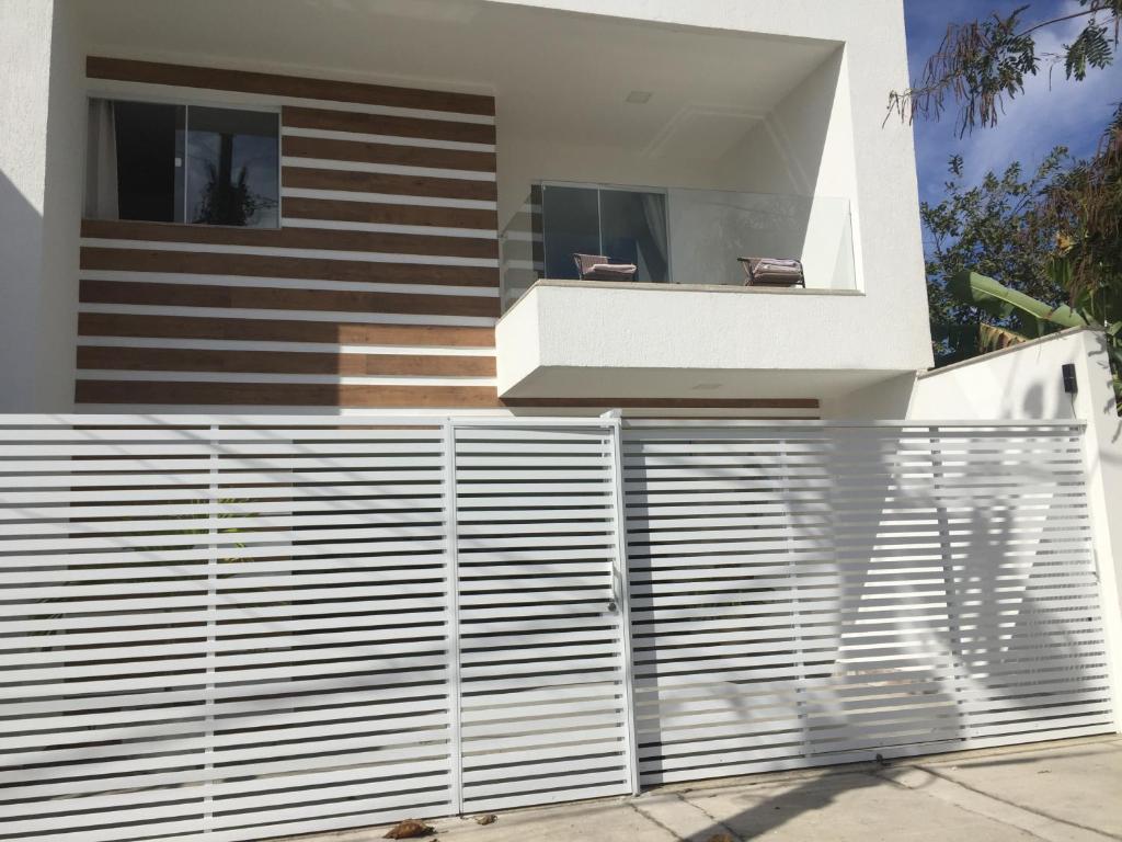 uma cerca branca em frente a uma casa em Apartamento Em Condominio Residencial Familiar em Cabo Frio