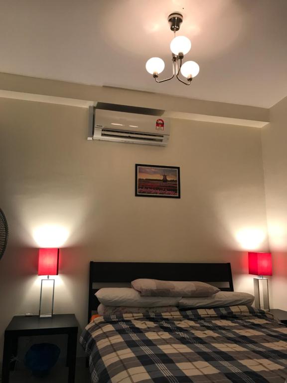 ein Schlafzimmer mit einem Bett mit 2 Lampen und einem Ventilator in der Unterkunft Heart of Petaling Jaya near LRT line 5 (3) in Petaling Jaya