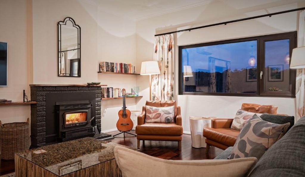 a living room with a fireplace and a guitar at Esto house in Crafers